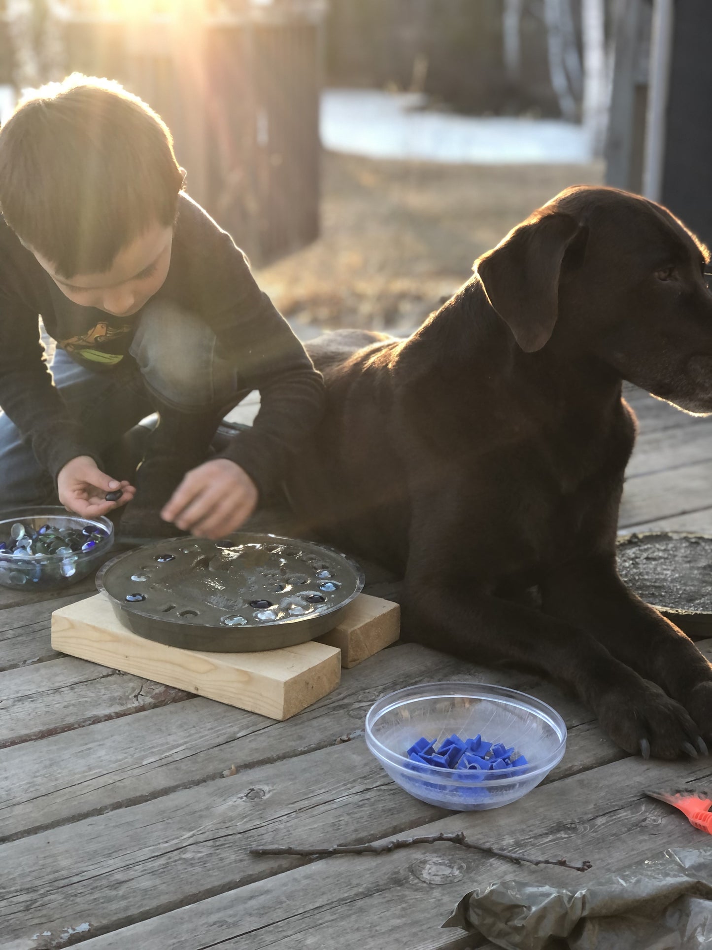 Child decorating his footprint stepping stone kit with mosaic glass gems. Children love making these easy to d kits!