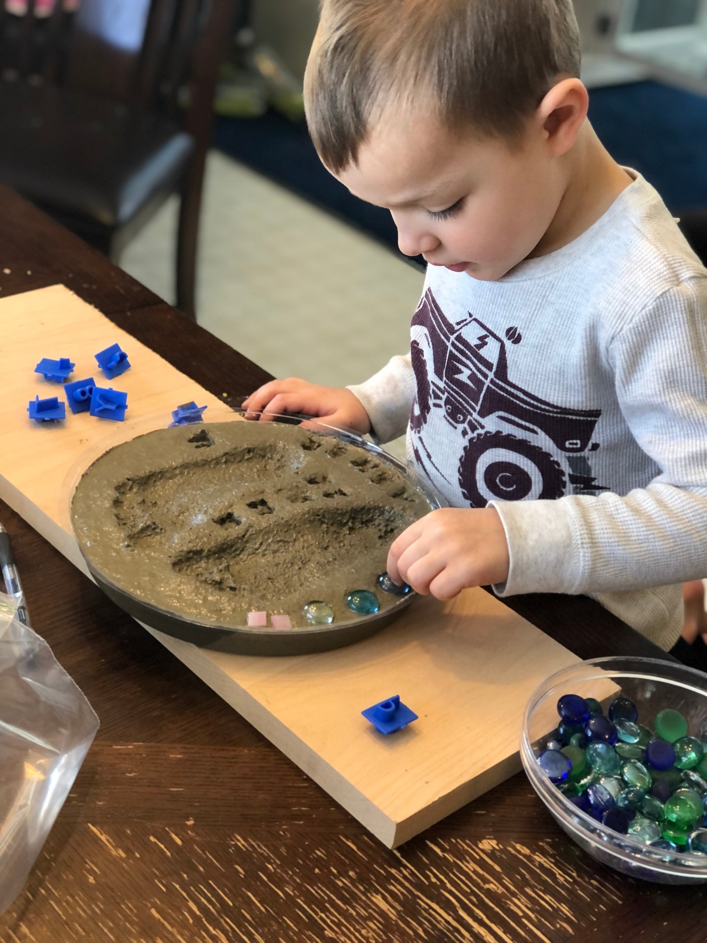 Child decorating his footprint stepping stone kit with mosaic glass gems. Children love making these easy to d kits!