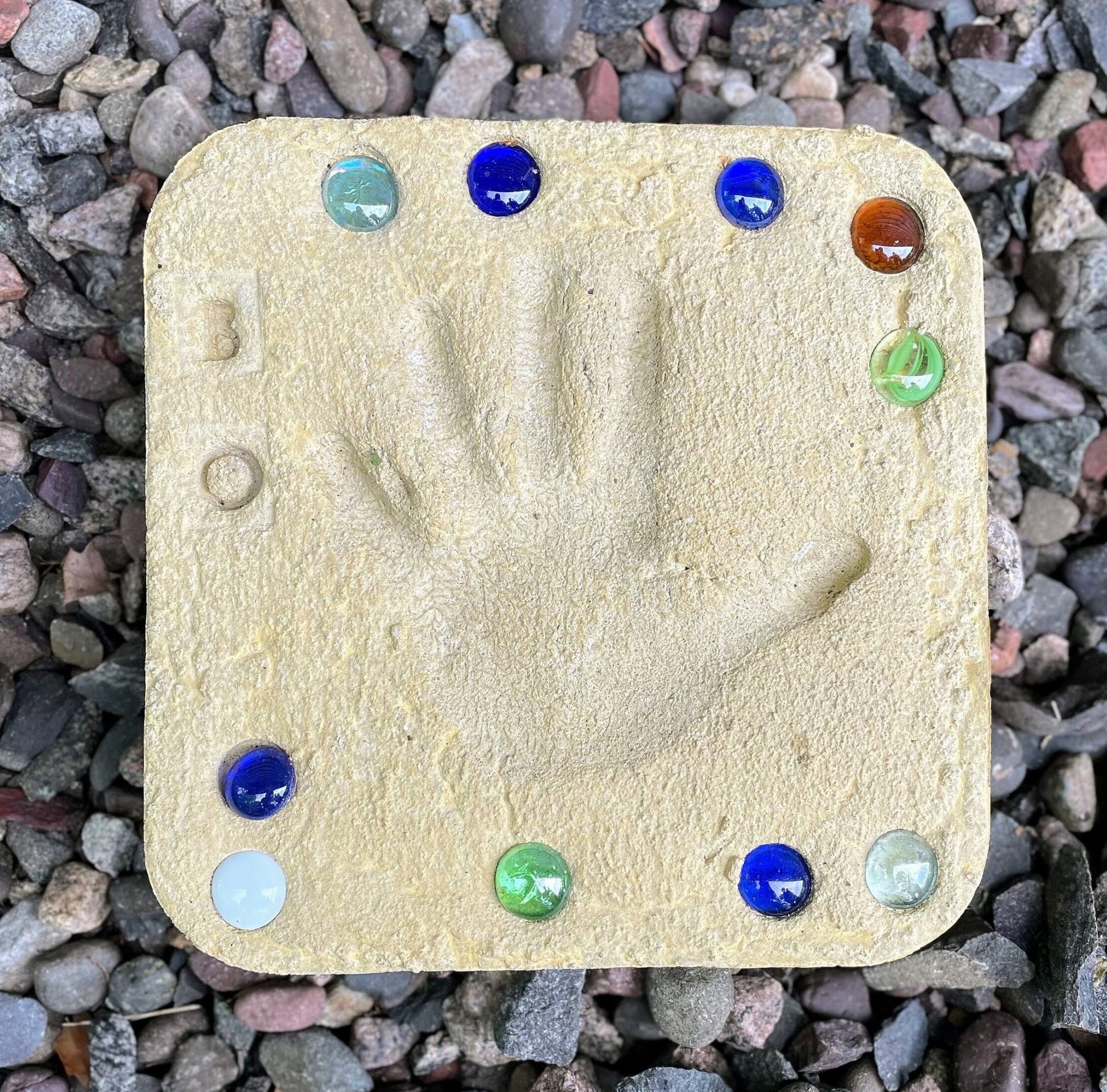colored square stepping stone displayed in garden